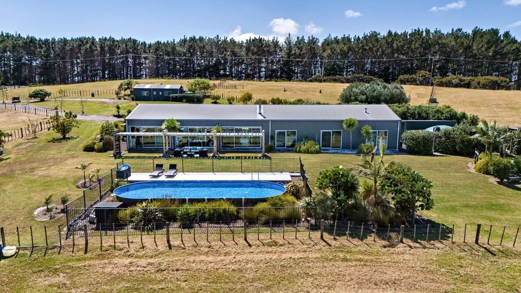 Aerial view of a modern rural home with an above-ground pool and landscaped garden