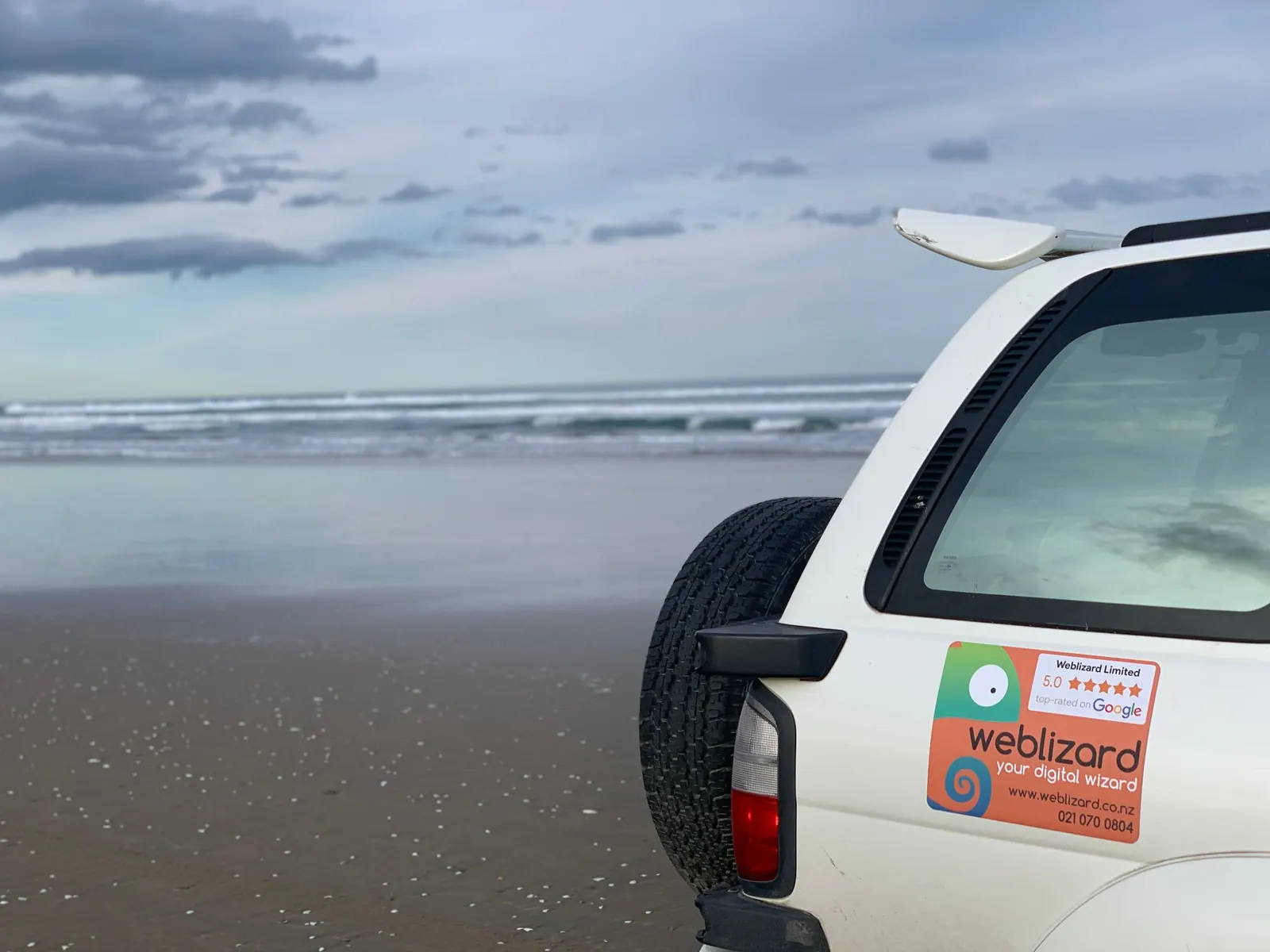 The Weblizard car parked on a beach